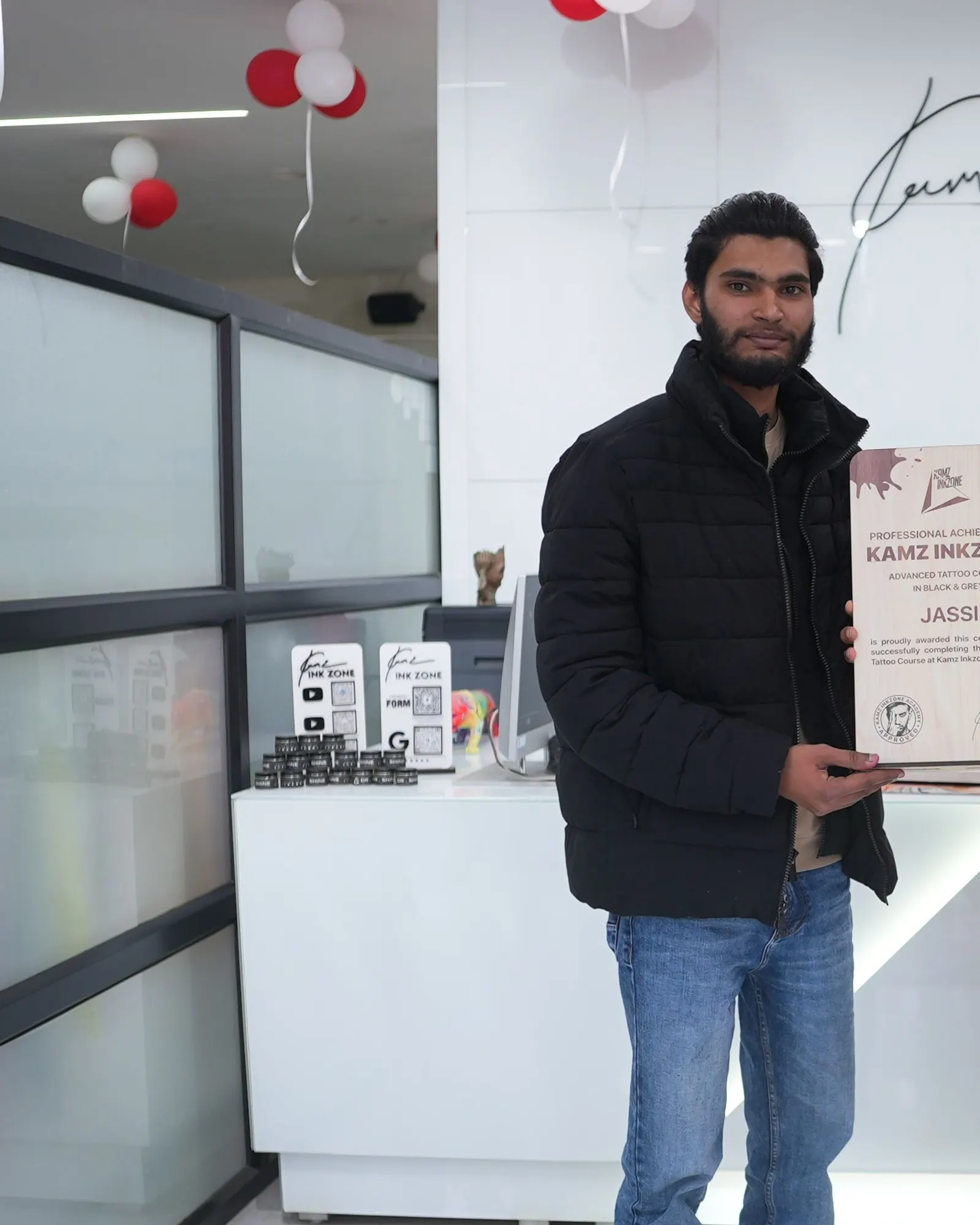 Jassi, holding the Kamz Inkzone Academy Advanced Tattoo Course certificate